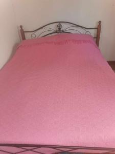 a pink bed with a pink bedspread on it at The Mouflon House Pedoulas in Nicosia