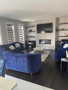 a living room with a blue couch and a tv at Luxury Modern smart home for vacation in Windsor