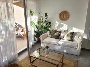 a living room with a couch and a glass table at Appartement terrasse proche Centre in Montpellier