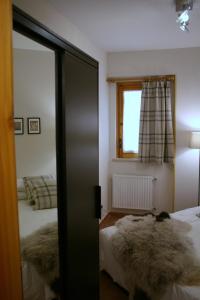 espejo en un dormitorio con 2 camas y ventana en Appartamento Arnolucci, en Rovere