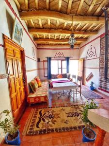 um quarto com uma cama e uma mesa em Maison d'Hôte Argana em Aït Idaïr