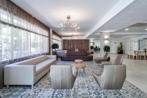 een lobby met een bank, stoelen en een tafel bij Hotel Best Oasis Park in Salou