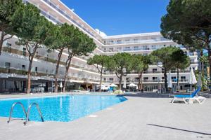 een zwembad voor een groot gebouw bij Hotel Best Oasis Park in Salou