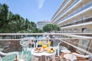 un balcón con una mesa con comida y bebidas. en Hotel Best Oasis Park, en Salou