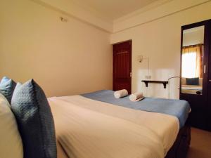 a bedroom with a bed with two towels on it at Ivy Retreat- Serviced Apartments in Baga
