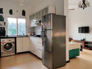 una cucina con frigorifero in acciaio inox e lavastoviglie di Ivy Retreat- Serviced Apartments a Baga