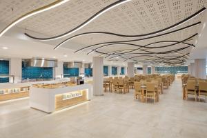 a large cafeteria with tables and chairs and a ceiling at Hotel Best Mediterraneo in Salou