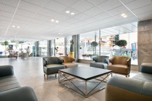 a lobby with chairs and a table in a building at Hotel Best San Diego in Salou