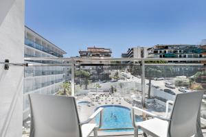 a balcony with two chairs and a swimming pool at Hotel Best San Diego in Salou