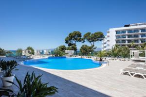 uma piscina num resort com cadeiras e um edifício em Hotel Best Punta Dorada em Salou