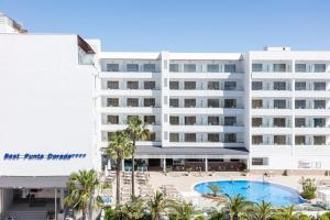 a large white hotel with a swimming pool and palm trees at Hotel Best Punta Dorada in Salou