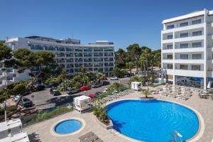 una vista aérea de una piscina con sillas y un edificio en Hotel Best Punta Dorada, en Salou