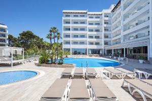 Hotel Best Punta Dorada في سالو: مسبح وكراسي صالة ومبنى