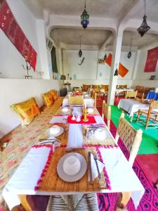 uma sala de jantar com uma mesa longa e cadeiras em Maison d'Hôte Argana em Aït Idaïr
