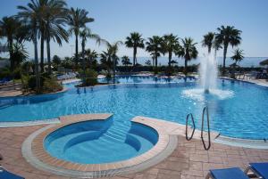 a large swimming pool with a fountain in the middle at Hotel Best Oasis Tropical in Mojácar