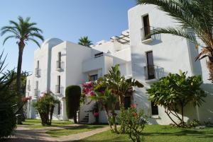 a white building with palm trees in front of it at Best Club Vacaciones Pueblo Indalo in Mojácar