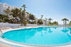a swimming pool at a resort with palm trees at Best Club Vacaciones Pueblo Indalo in Mojácar