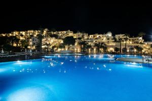 a large pool of blue water with buildings in the background at Best Club Vacaciones Pueblo Indalo in Mojácar