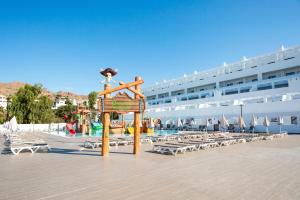a resort with a playground and a pool with chairs at Best Club Vacaciones Pueblo Indalo in Mojácar
