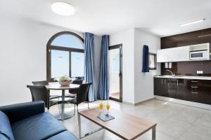 a living room with a blue couch and a table at Best Club Vacaciones Pueblo Indalo in Mojácar