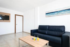 a living room with a blue couch and a table at Best Club Vacaciones Pueblo Indalo in Mojácar