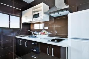 a kitchen with a sink and a white refrigerator at Best Club Vacaciones Pueblo Indalo in Mojácar