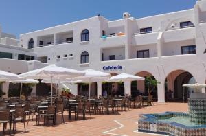 a building with tables and chairs and umbrellas at Best Club Vacaciones Pueblo Indalo in Mojácar
