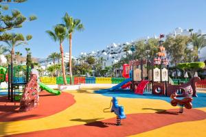 a playground at a resort with a slide and swings at Best Club Vacaciones Pueblo Indalo in Mojácar