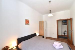 a bedroom with a large bed and a bathroom at Apartment Stross Rijeka in Rijeka