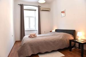 a bedroom with a bed with a stuffed animal on it at Apartment Stross Rijeka in Rijeka