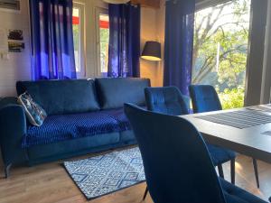uma sala de estar com um sofá azul e uma mesa em Domki że Hej Bieszczady em Ustrzyki Dolne