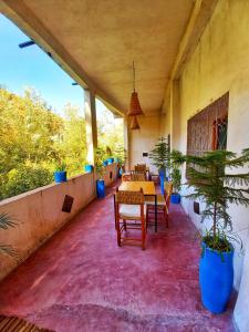 un patio con mesas y sillas y una maceta en Maison d'Hôte Argana en Aït Idaïr