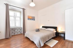 a bedroom with a bed and a large window at Apartment Stross Rijeka in Rijeka