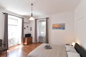 a bedroom with a bed and a large window at Apartment Stross Rijeka in Rijeka