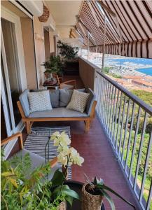 a porch with a couch on a balcony at Ajaccio . chambre avec vue in Ajaccio