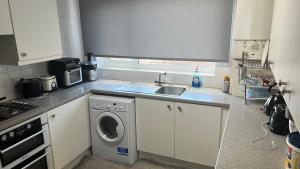 a kitchen with a sink and a washing machine at Private room in Amley