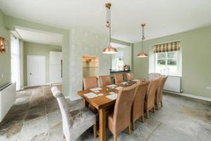 a dining room with a wooden table and chairs at Coach House, Middleton Hall Estate in Belford