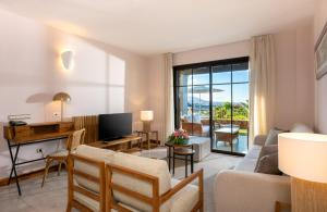 a living room with a couch and a tv at Hotel Suite Villa Maria in Adeje