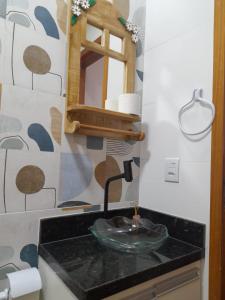 a bathroom with a sink and a mirror at Suíte Itaipu Mar in Vila Velha