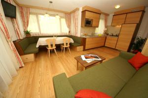 a living room with a green couch and a table at Miribunghof in La Valle