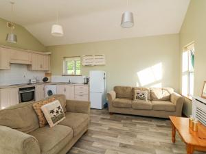 a living room with two couches and a kitchen at Valley View in Enniscorthy