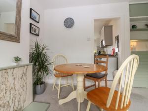una cucina e una sala da pranzo con tavolo e sedie in legno di 2 Station Road East a Peterculter