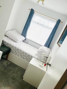 a small bed in a room with a window at Khan's Living Lakeside Drive Cyncoed Cardiff in Cardiff