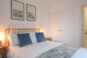 a bedroom with a bed with blue pillows at Lyme Zest in Lyme Regis