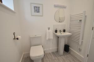 a white bathroom with a toilet and a sink at Lyme Zest in Lyme Regis +31 photos