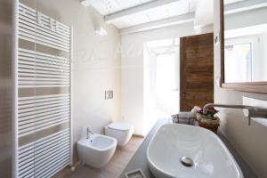 uma casa de banho branca com um lavatório e um WC em Casa Castagna 1620 em Mergozzo