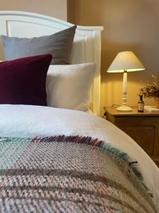 a bedroom with a bed and a lamp on a table at Idyllic cosy cottage close to Oxford and Le Manoir in Cuddesdon