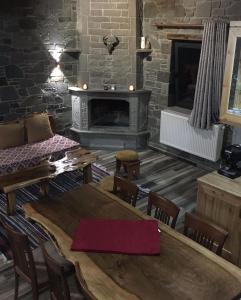 a living room with a wooden table and a fireplace at Kulla Relax in Elbasan