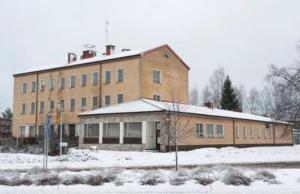 een groot bakstenen gebouw met sneeuw ervoor bij Hotelli Posti in Äänekoski