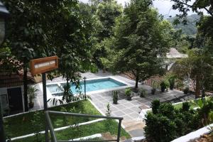 a swimming pool in a yard with trees at Vanilla County Heritage Plantation Bungalow in Vagamon